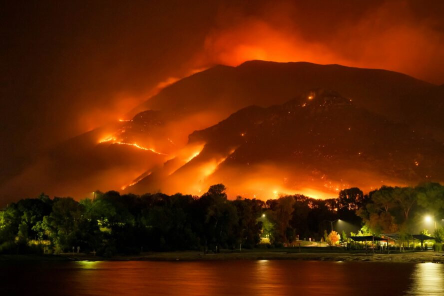 Photo by Mike Newbry on Unsplash - A large fire is burning in the mountains